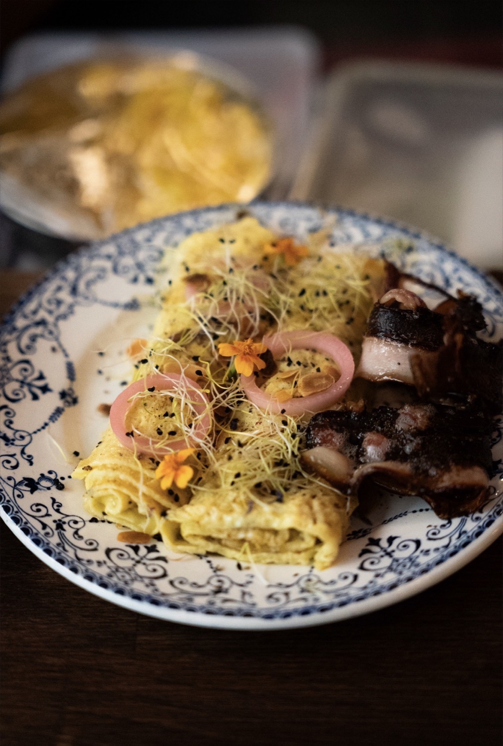 Egg roll servi avec bacon croustillant et micro-pousses